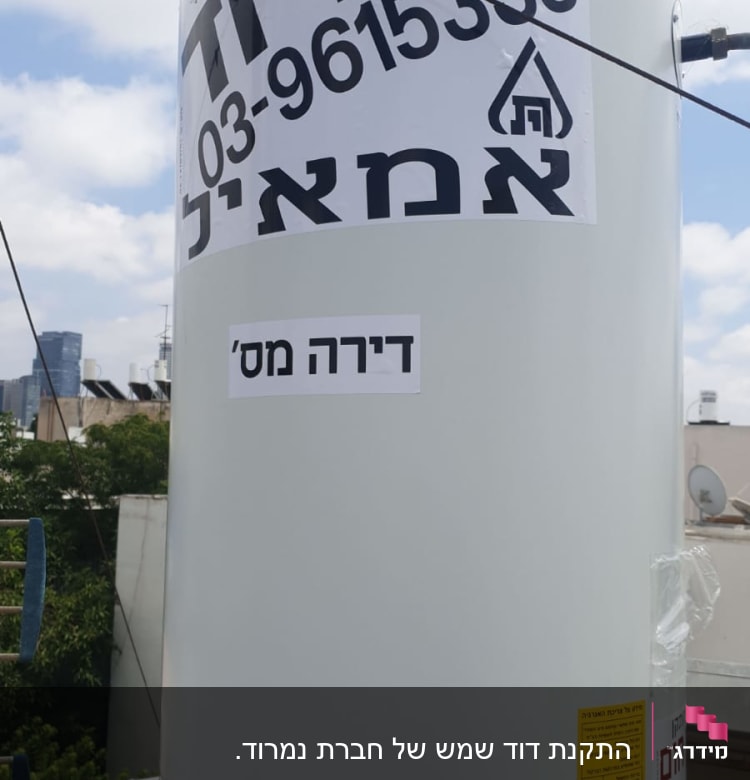 דוד שמש עם מדבקות טקסט בעברית על גג